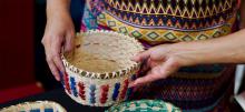 Handing a colorful woven basket.