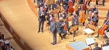 Ricardo Lorenz receiving applause with an orchestra behind him